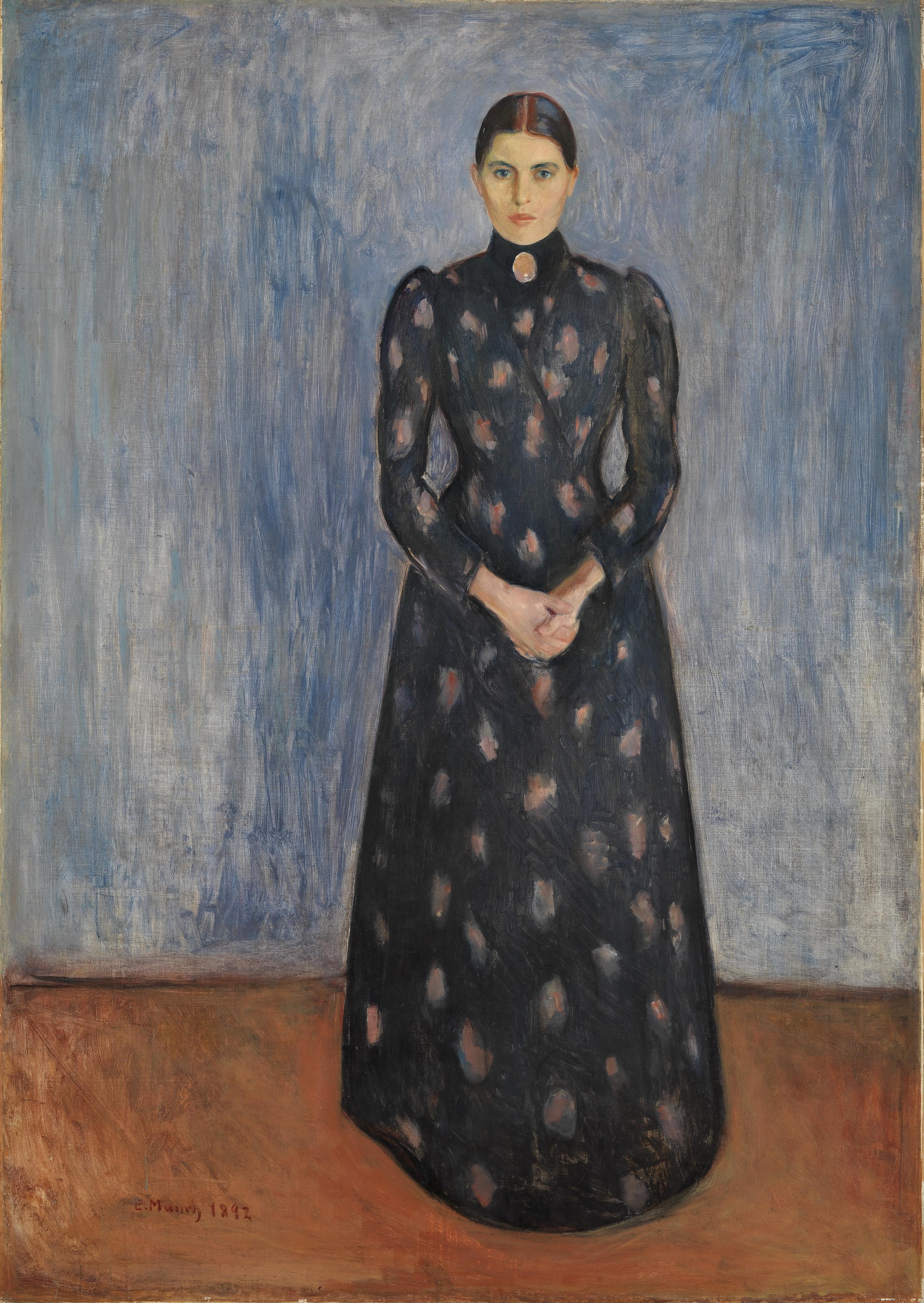 Edvard Munch, Inger in Schwarz und Violett: eine junge Frau in dunklem, bodenlangem Kleid steht aufrecht vor einer blaugrauen Wand, die Hände vor der Taille gefaltet, an der Kehle eine ovale Kamee; handgemalte Reproduktion.