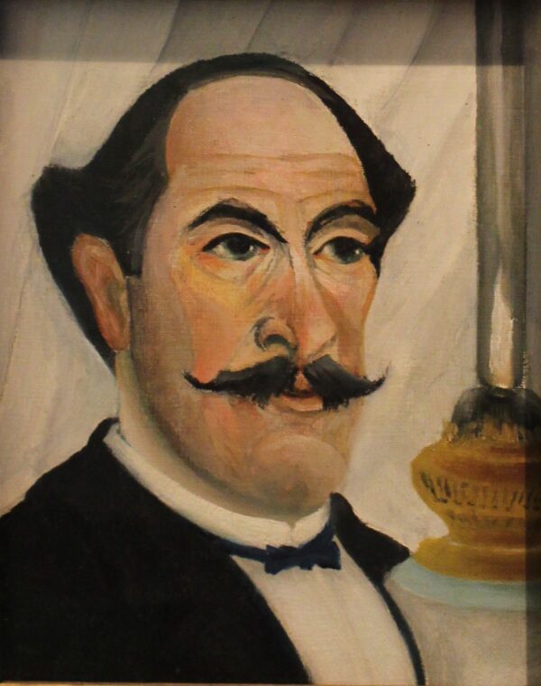 Ritratto dell’artista con la lampada, Henri Rousseau – un uomo dalla fronte alta e dai grandi baffi in giacca nera davanti a una tenda più chiara, a destra una lampada a olio accesa col camino di vetro