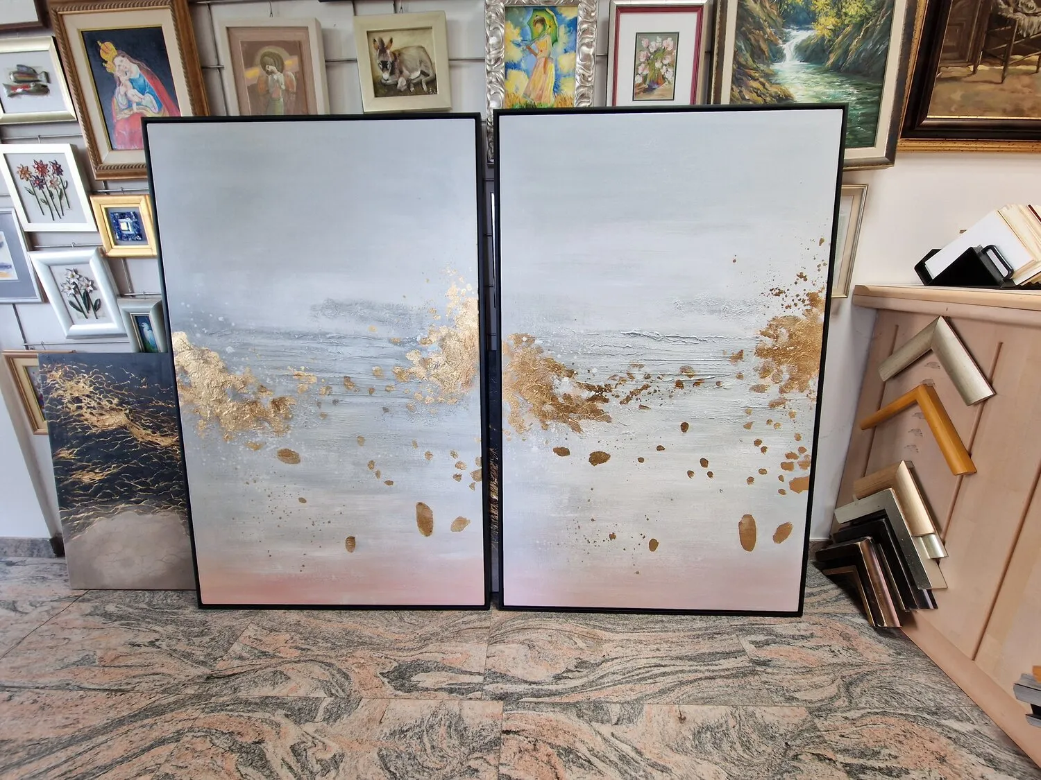 Tableau sur toile – Gouttes d’or – deux toiles côte à côte, appuyées contre le mur de l’atelier d’encadrement, dans un cadre au choix en option